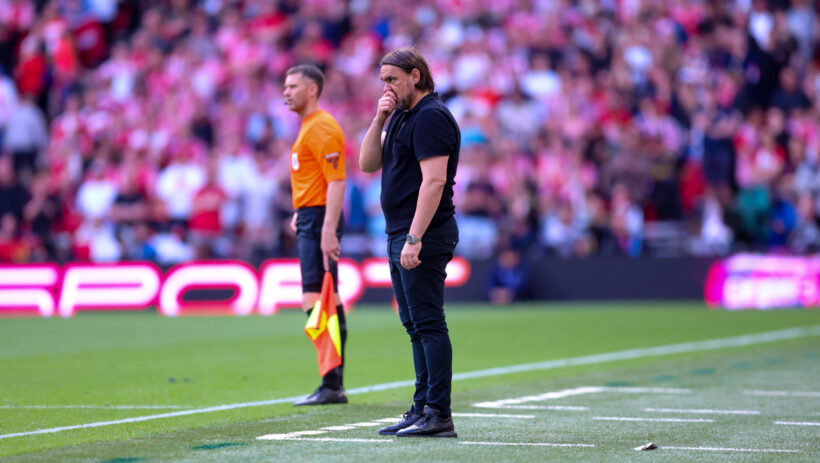Daniel Farke in a thoughtful pose during a Leeds United match, reflecting the challenges of club management.