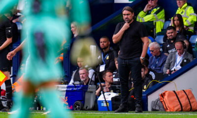 Daniel Farke deep in thought on the sidelines during a Leeds United match.