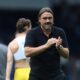 Daniel Farke clapping and showing appreciation after a Leeds United match.